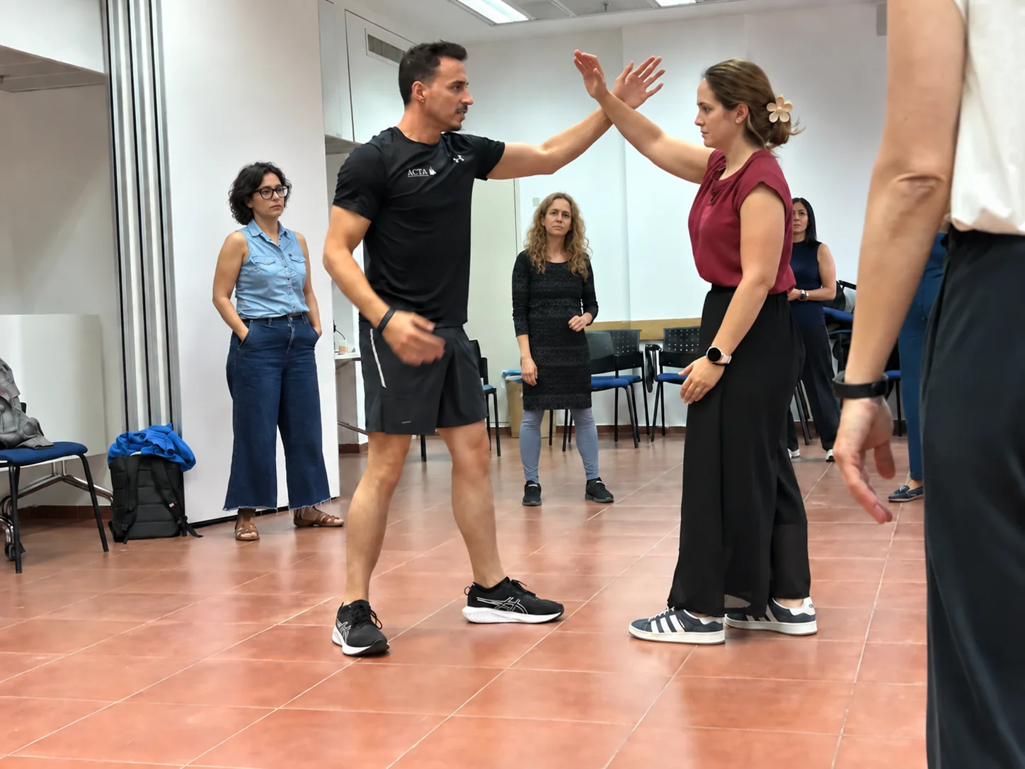 עידן גל מדגים טכניקת הגנה עצמית עם משתתפת בסדנה