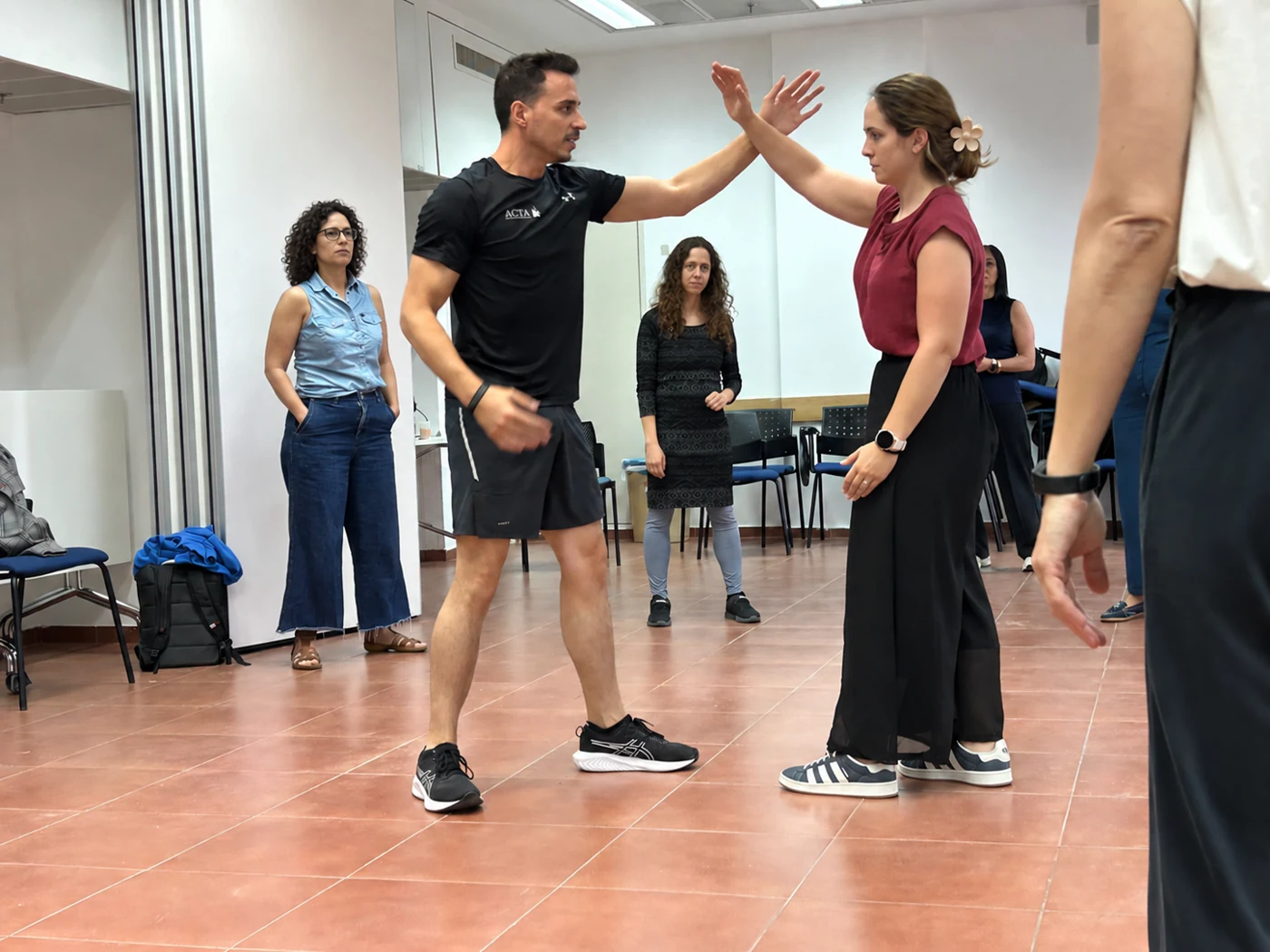 עידן מדגים הגנה מעשית עם משתתפת בסדנה